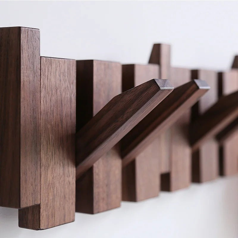 Wandgarderobe aus Holz im Klaviertasten-Design mit ausgeklapptem Haken