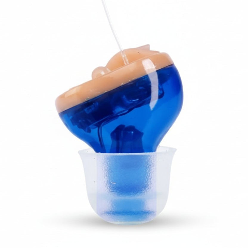 Kleiner blauer In-Ear-Hörverstärker mit transparentem Ohrstöpsel auf einem Waschtisch